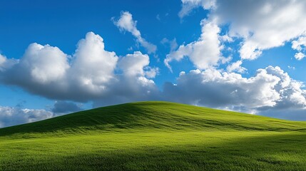 Fototapeta premium Tall wind turbines stand on lush green hills with a background of dynamic clouds and vivid blue sky, symbolizing clean and environmentally friendly renewable energy production.