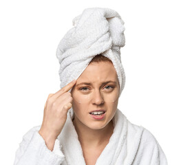 Young Caucasian redhead after shower showing a disappointment gesture with forefinger.
