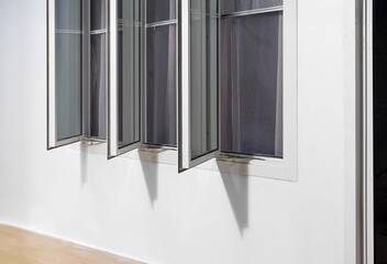 Three panel aluminium casement window stay on white wall.