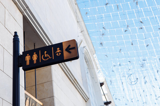 Directional sign indicating restrooms and accessibility features in public space