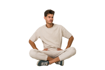 Young caucasian man sitting on the floor isolated on white background confused, feels doubtful and unsure.