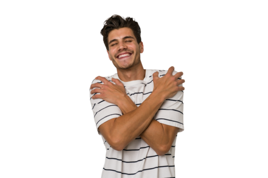 Young handsome caucasian man isolated on white background hugs, smiling carefree and happy.