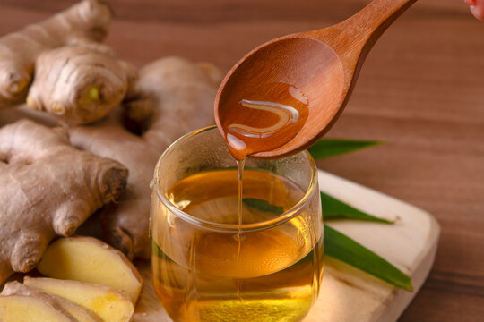 Cup of tea with ginger root on a wooden table, Ginger tea with and honey on a gray background. - Powered by Adobe