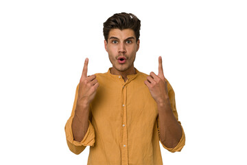 Young handsome caucasian man isolated on white background pointing upside with opened mouth.