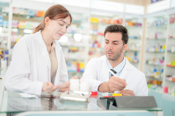 team man and woman pharmacist inspects a medication bottle, ensuring accuracy in prescription...
