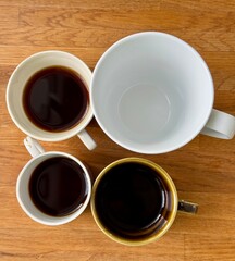 cup of coffee in different sizes on a wooden table