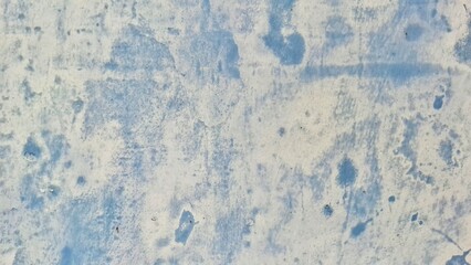 An abstract close-up of a textured surface with a mix of blue and white tones. This image displays a rough, aged appearance, perfect for backgrounds or design elements.