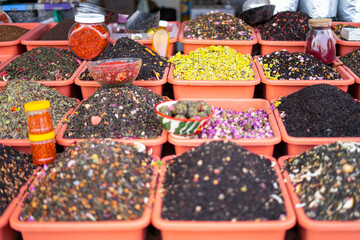 Variety of Colorful Spices Displayed in Plastic Containers at a Market in Uzbekistan