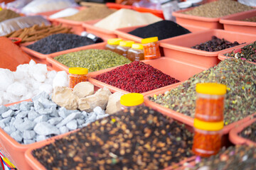 Variety of Colorful Spices Displayed in Plastic Containers at a Market in Uzbekistan