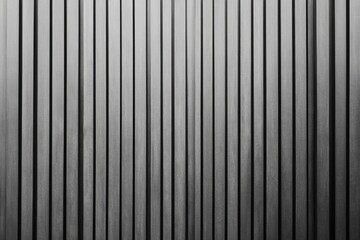 Vertical slatted wall, gray tones  Close-up view of parallel, evenly spaced, rectangular panels