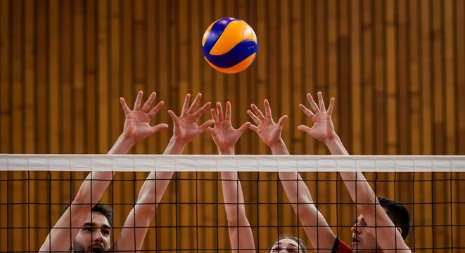 Intense Volleyball Match: Players Reaching for the Ball Over the Net