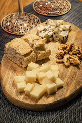 A table of cheese and nuts with a glass of red wine