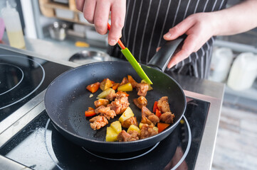 The chef fries pork in sweet and sour. 
