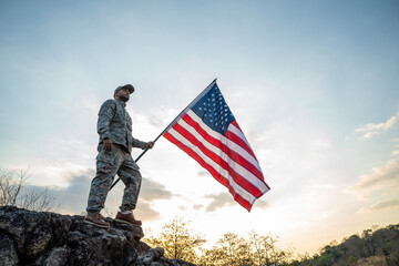 Hand Waving the Flag of the United States of America in memorial day . Us soldier holding American flag celebrating.US Army soldier celebrates holding USA flag celebrating Independence USA day