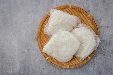 Steamed sticky rice in clear plastic food bag  top view food table on grey cement background