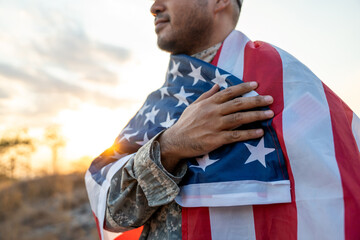 Hand Waving the Flag of the United States of America in memorial day . Us soldier holding American...