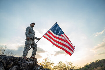 Hand Waving the Flag of the United States of America in memorial day . Us soldier holding American flag celebrating.US Army soldier celebrates holding USA flag celebrating Independence USA day