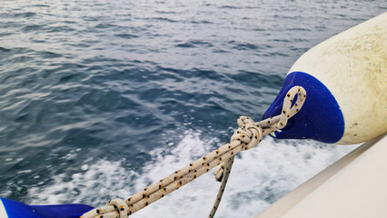 Boat bumper tied to the side of the boat. Marine fender or boat bumper close-up. Sea trip....