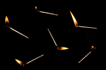 Lit and falling match on a black background.