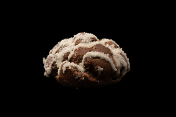 Profiteroles with coconut cream on a black background.