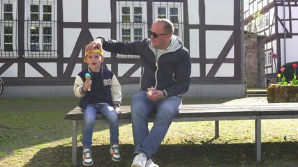 Father and Son Enjoy Ice Cream on Bench Outdoors