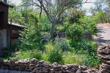 Improvised decorations in the front garden.
The small front garden is fenced with natural stone and decorated with an old bicycle that serves as a statue.