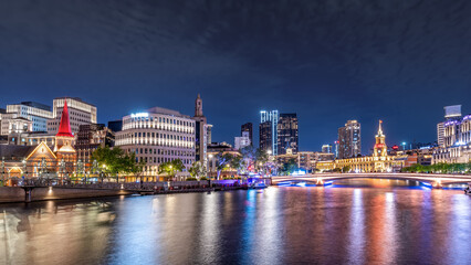 Fototapeta premium Captivating City Nightscape Reflecting on Tranquil River with Illuminated Skyscrapers