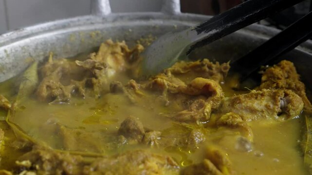 A large pot of chicken curry simmering on the stove
