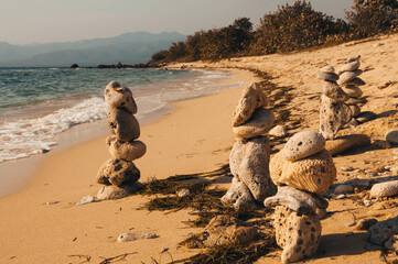 Stone cairns stand proudly on a sandy beach, embodying balance, mindfulness, and the serene beauty of nature