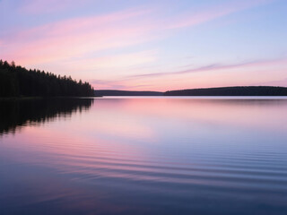Scenic view of a calm lake during sunset, with soft ripples on the water