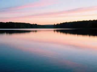 Obraz premium Scenic view of a calm lake during sunset, with soft ripples on the water