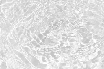 White water with ripples on the surface. Defocus blurred transparent white colored clear calm water surface texture with splashes and bubbles. Water waves with shining pattern texture background.