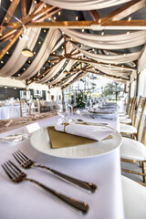 Wedding setting and decorated tables in a beautiful modern interior of a performance hall with a modern light ceiling of wooden construction