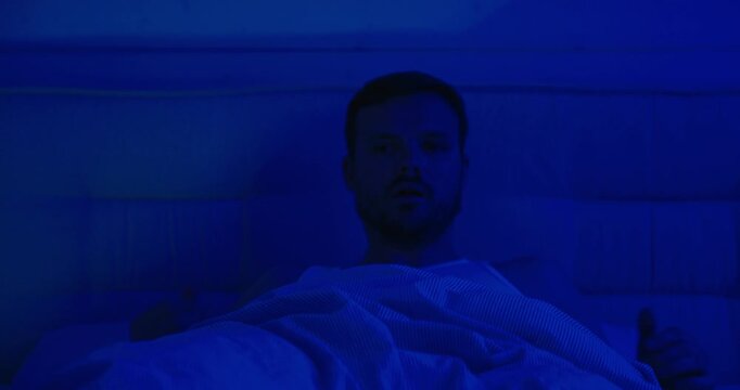 man wakes up in bed and had a nightmare in the night