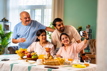 Capturing moments at breakfast, Indian son clicks selfie with parents and sister at table