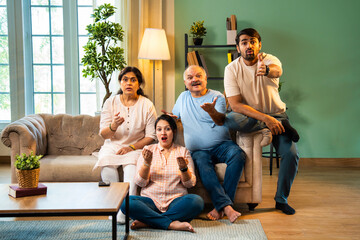 Sitting on sofa, Indian family points and laughs in shock after spotting something unexpected