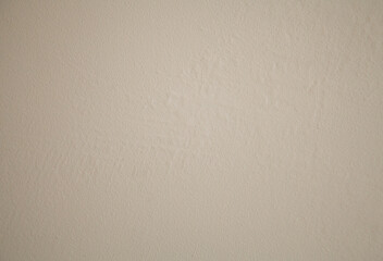 Textured beige plaster wall with swollen and cracked areas. Timeworn, rustic surface for design backgrounds