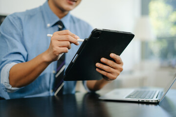 Confident businessman working on laptop, tablet and smartphone at her workplace