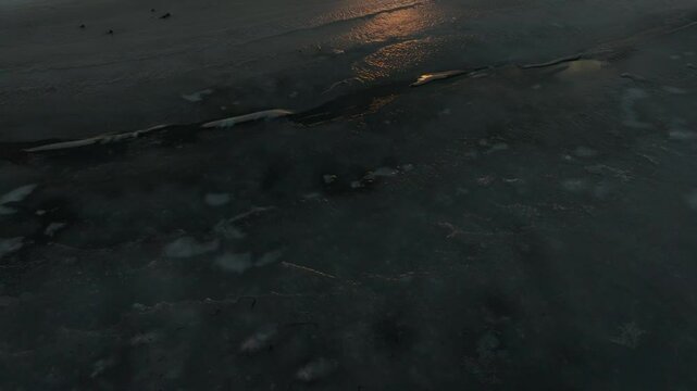 Low Flight Above Frozen Tidal Flats With Leafless Tree Woods At Sunset In Notsuke Peninsula, Hokkaido, Japan. drone tilt-up shot