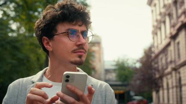 Pensive traveler tourist confused Hispanic man guy male using mobile phone map navigation walking in city going to location searching address navigator go at street application smartphone location