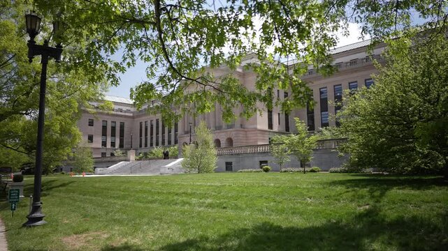 Kentuckys State Capitol Annex in Frankfort features impressive architecture, with lush green lawns and trees surrounding the structure on a sunny day.