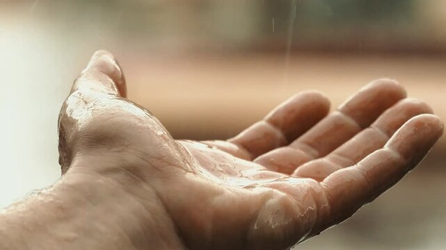 Raindrops fall into an open hand, symbolizing surrender and the unspoken language between human fragility and the vastness of the storm.