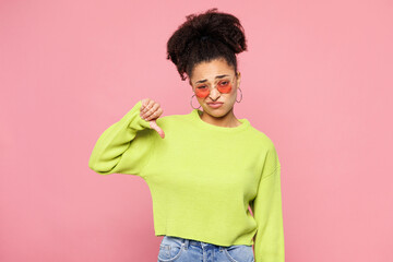 Young sad woman of African American ethnicity she wears green sweater casual clothes showing thumb...