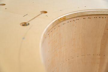 Meuble en bois aux formes arrondies fabriqué artisanalement dans un atelier de menuiserie, mettant...