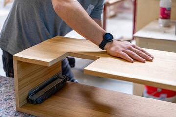 Meuble en bois aux formes arrondies fabriqué artisanalement dans un atelier de menuiserie, mettant en valeur le savoir-faire traditionnel et le design contemporain.