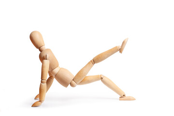 A wooden mannequin doing exercises on white background with copy space