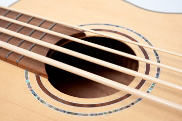 Four-string bass ukulele with wooden body and built-in tuner and pickup.
