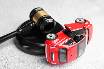Motor vehicle accident law. Gavel and car model on grey background