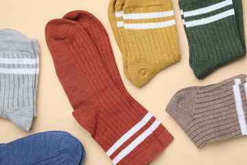 Many different pairs of socks on beige background, flat lay