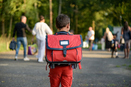 view of a child going to school with a schoolbag on his back on the first day of school